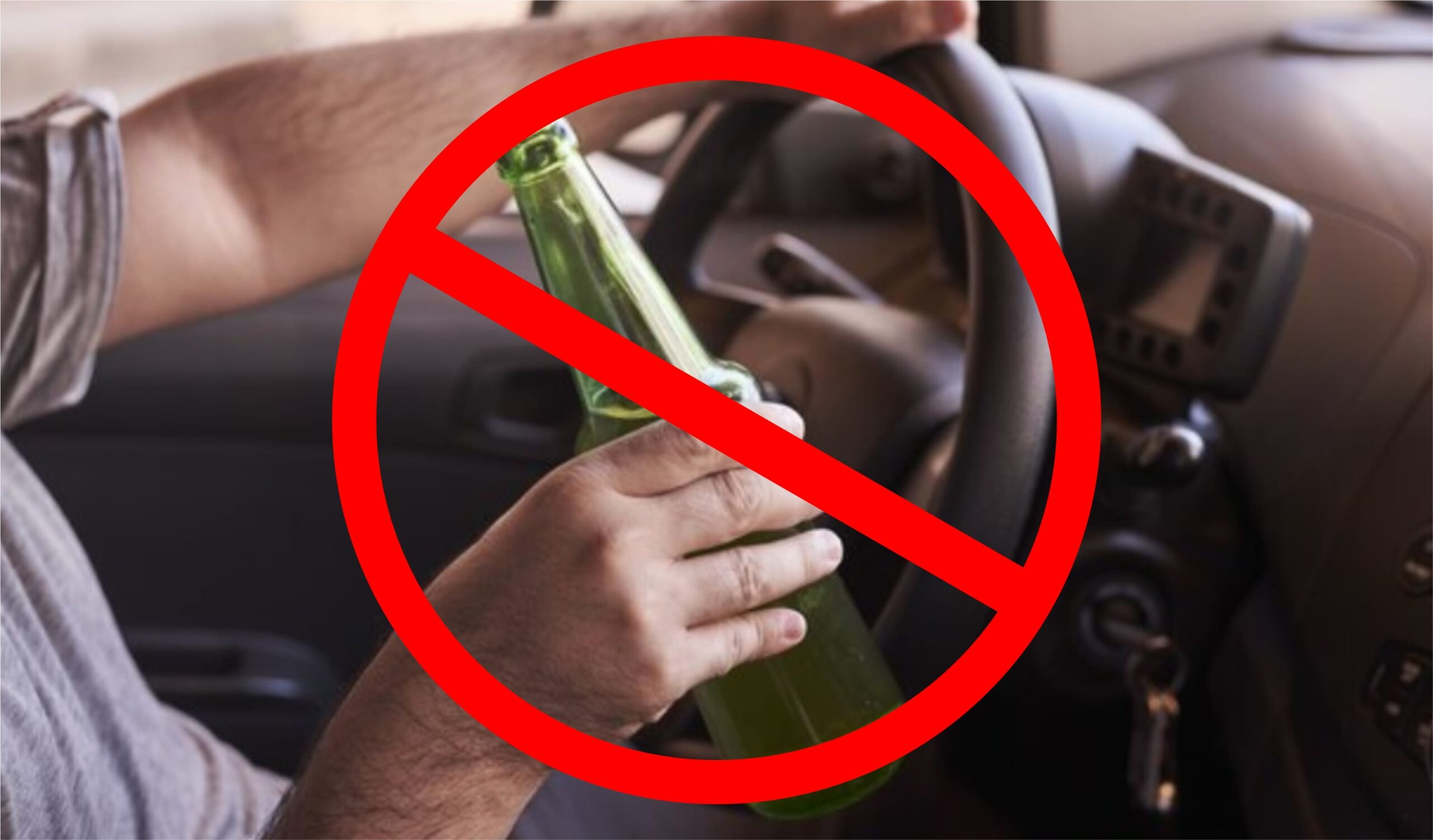 a hand holding a bottle and steering wheel