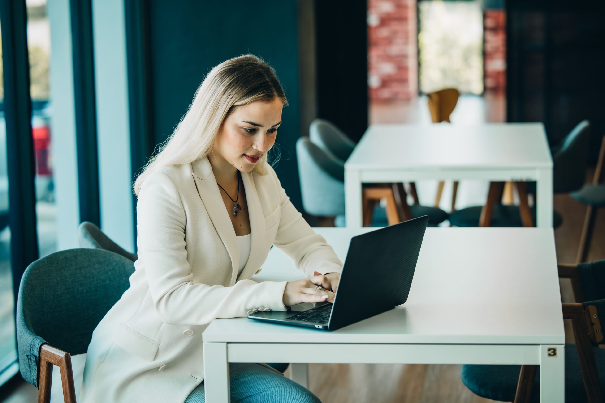 a woman sitting at a table using a laptop